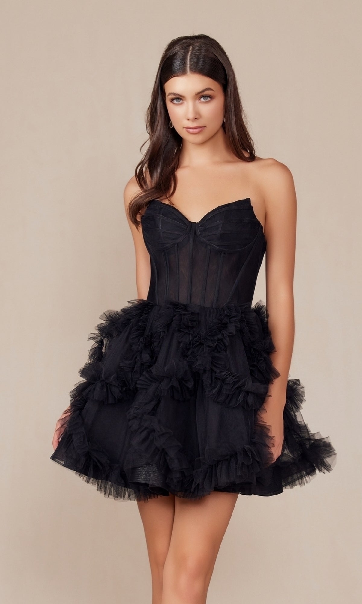 A woman models the Short Strapless Ruffled Homecoming Dress Y859, featuring a fitted bodice and layered tulle skirt, standing against a plain beige background.